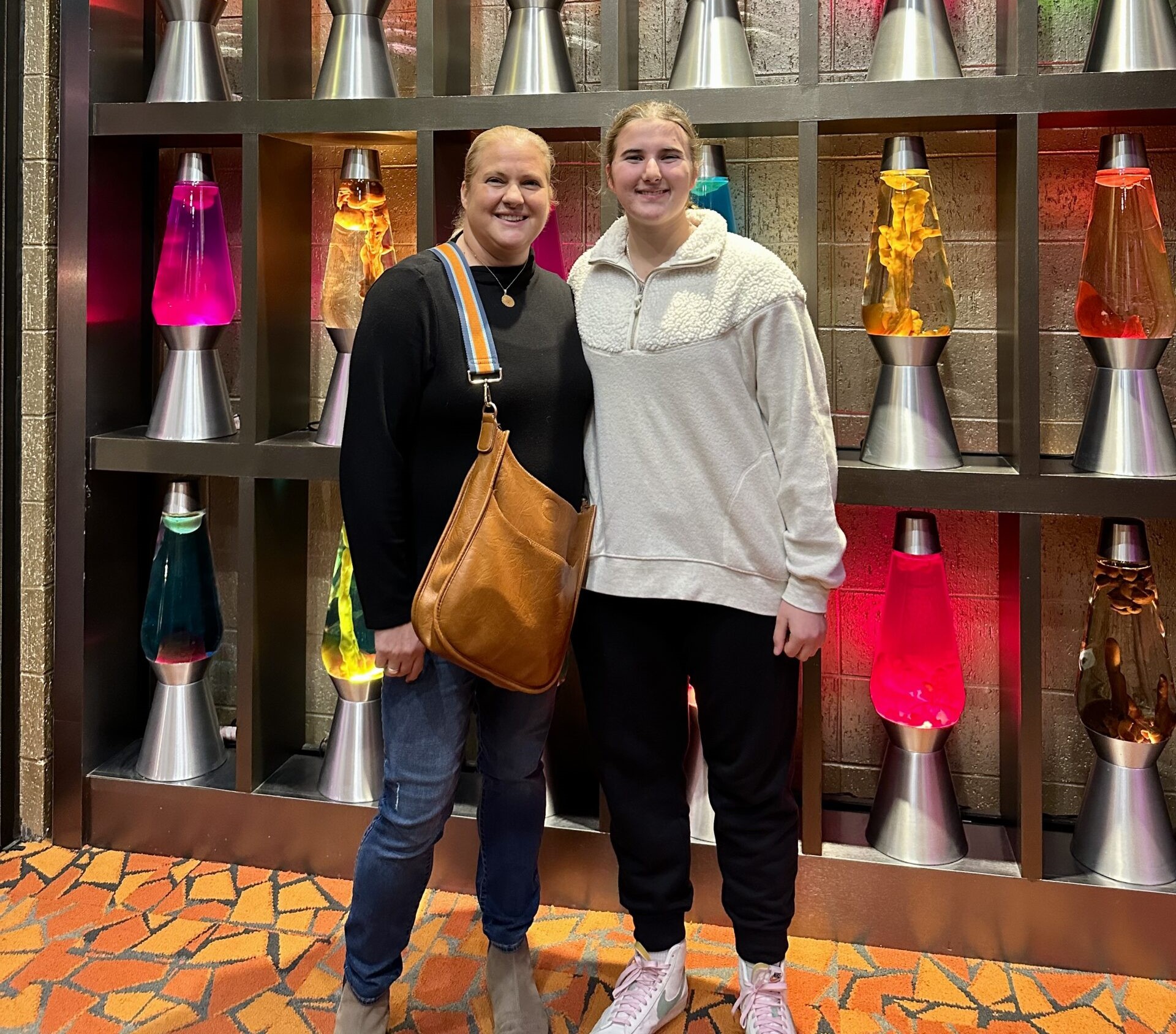 Two people in front of lava lamp wall